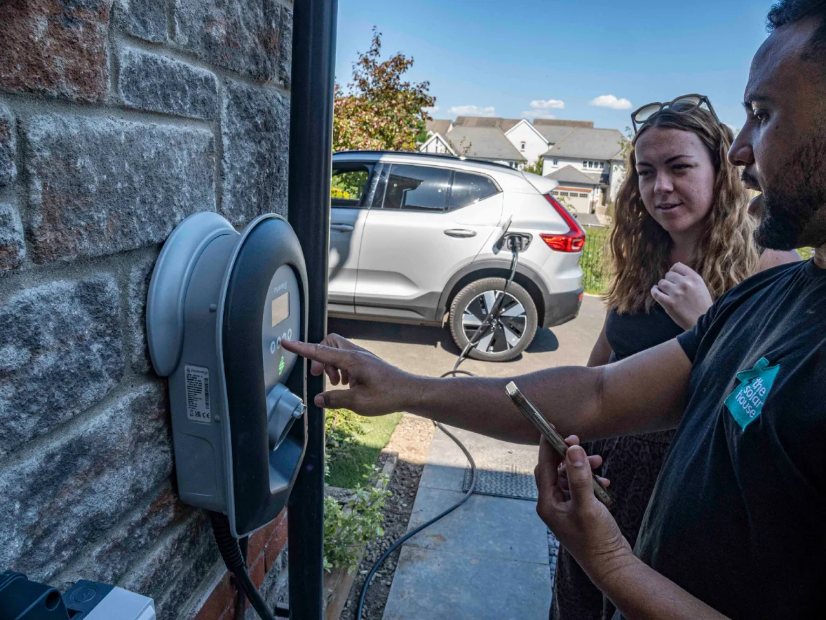 An installer showing a homeowner how to use her new EV charger