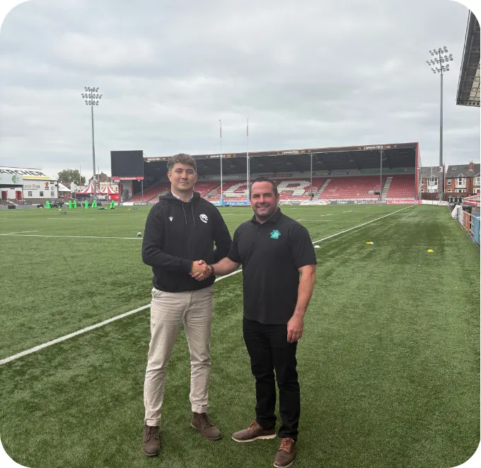 Shaking hands on the pitch at a rugby club The Solar House supports