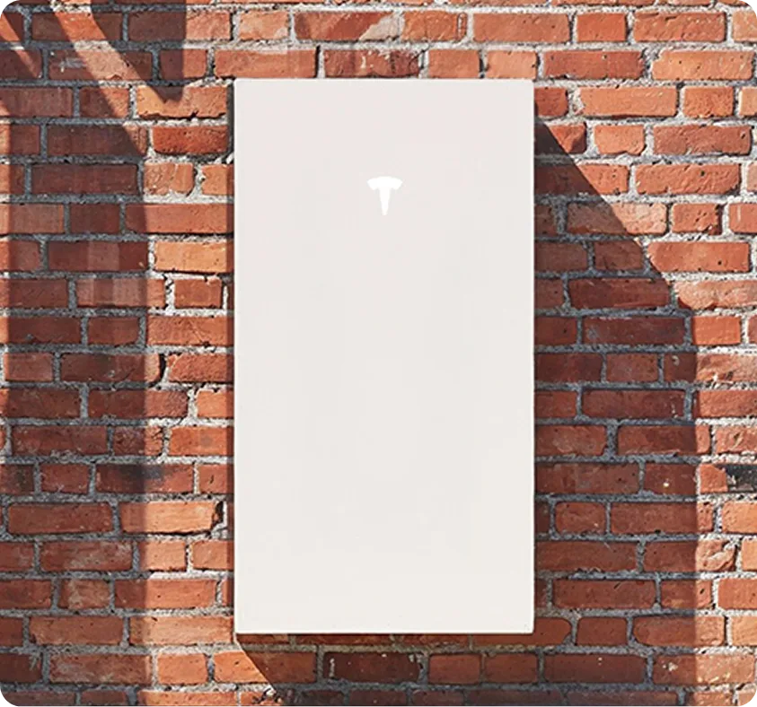 A Tesla Powerwall fitted on a brick wall