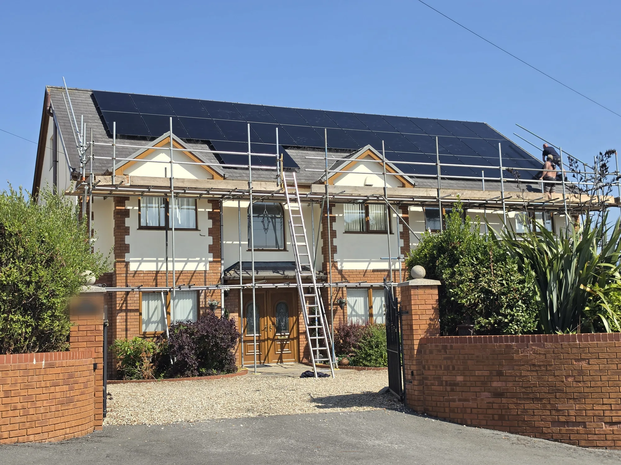 The home in Cefneithin, Llanelli, with 34 LONGi panels on the roof and the team finishing up on the scaffold