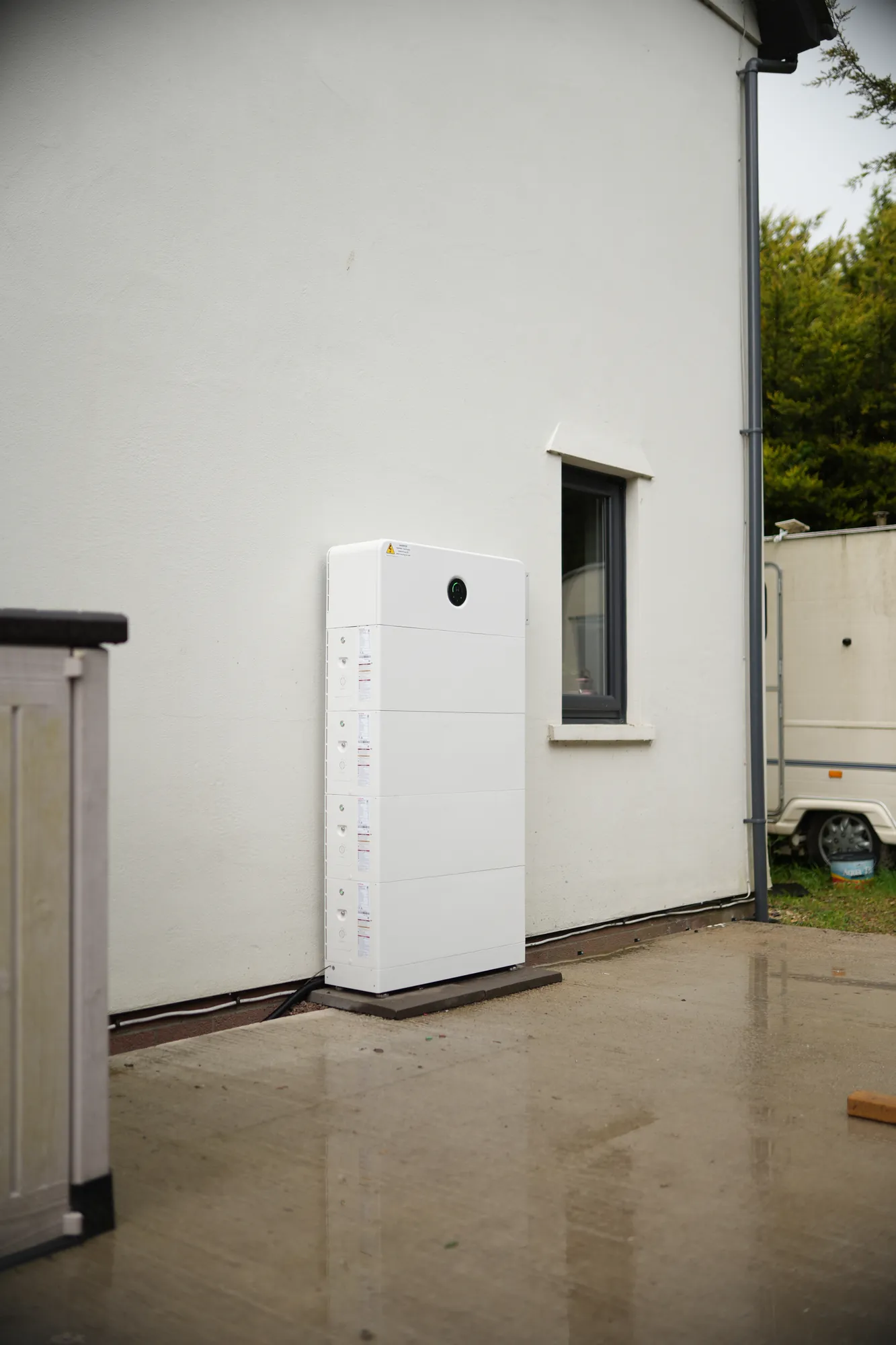 The four-battery GoodWe stack on the side wall of the house