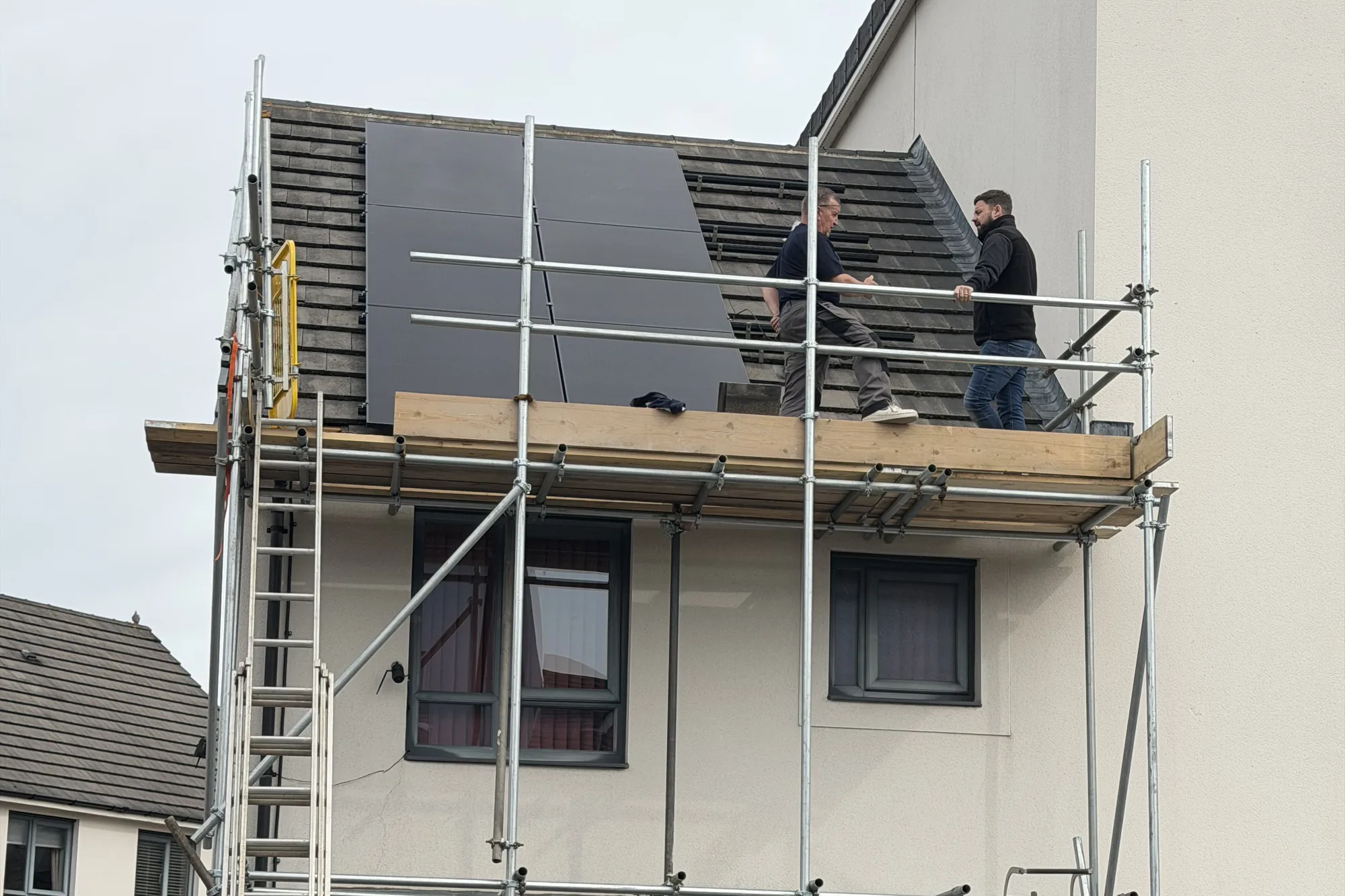 Our team on the scaffold with the nine AIKO panels fitted on the roof of the Newport home
