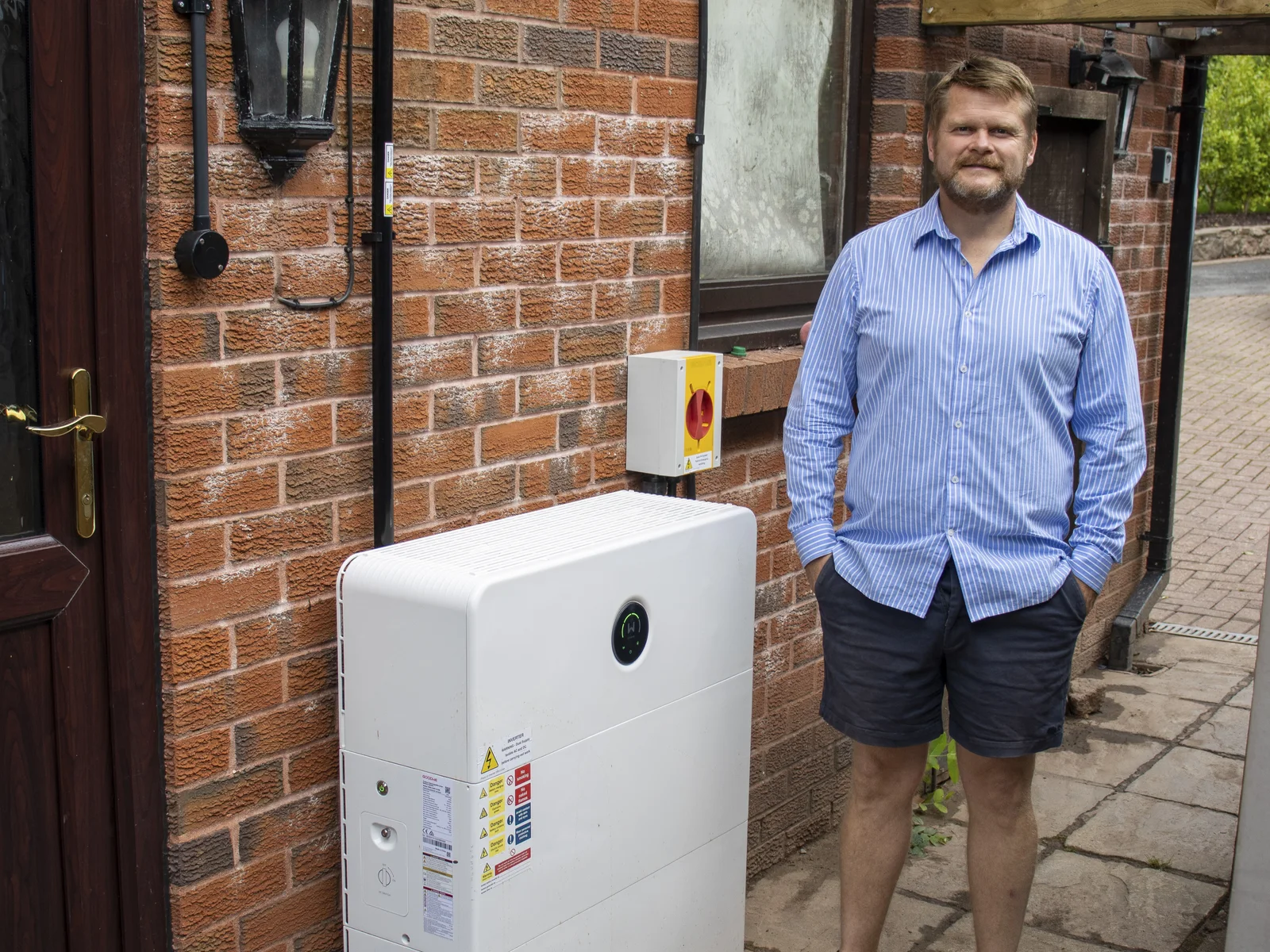 Rob beside his GoodWe battery and inverter at home in North Cardiff