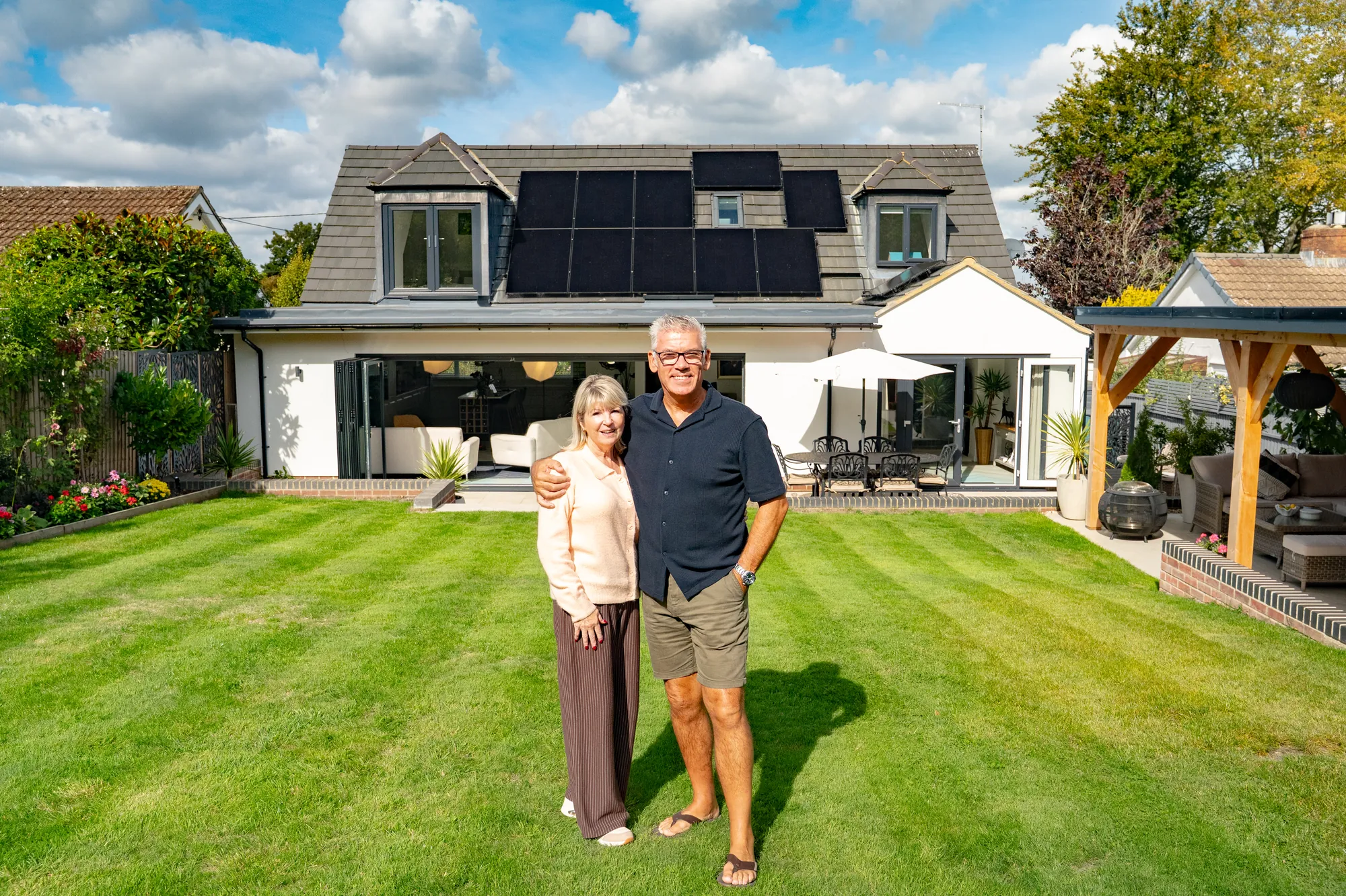 The homeowners in their garden in Westbury with the finished solar system behind them