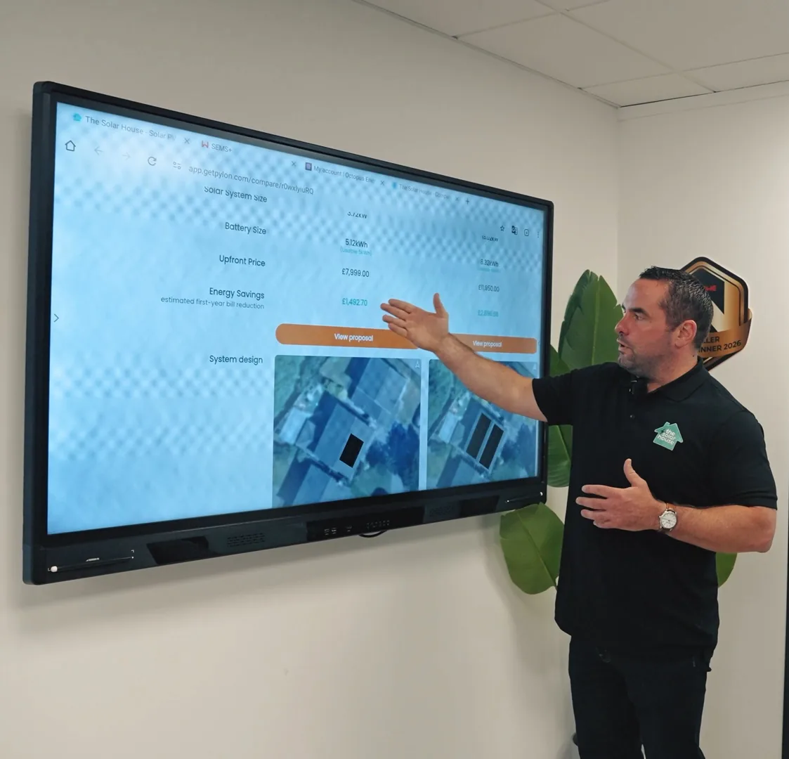Dan from The Solar House pointing at a home's solar system design on the showroom screen