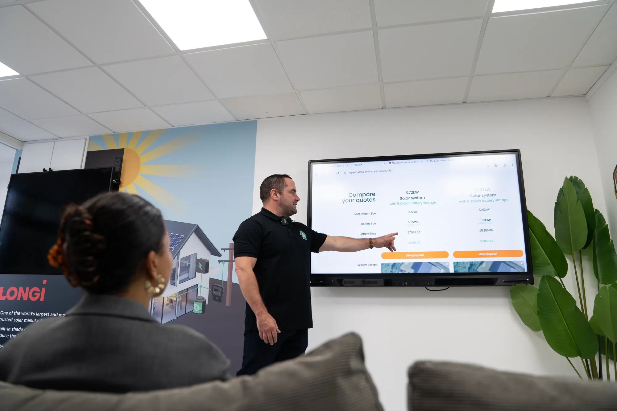 Dan from The Solar House talking a customer through her system proposal on the showroom screen