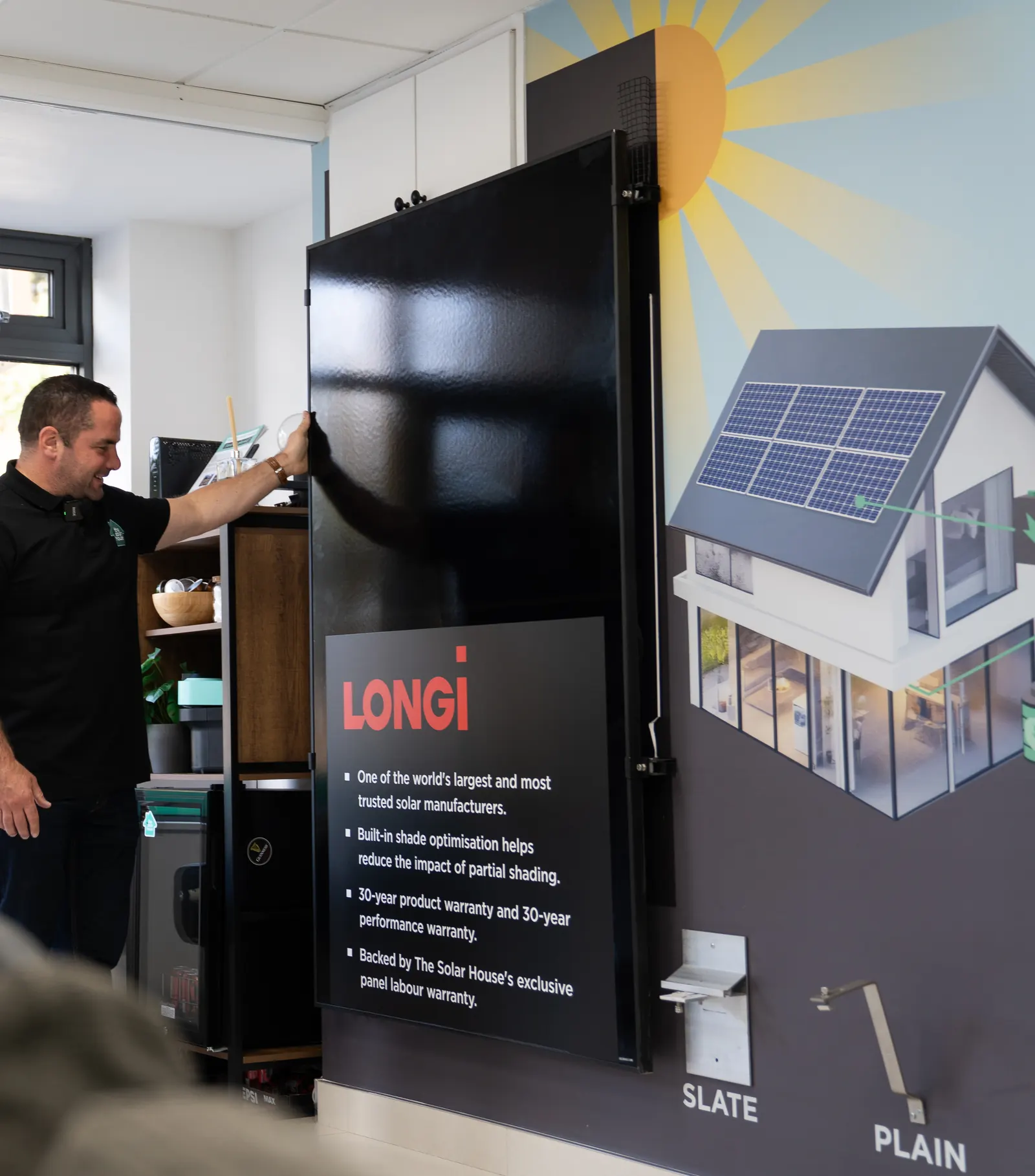 A Solar House adviser showing a customer LONGi solar panels in the showroom