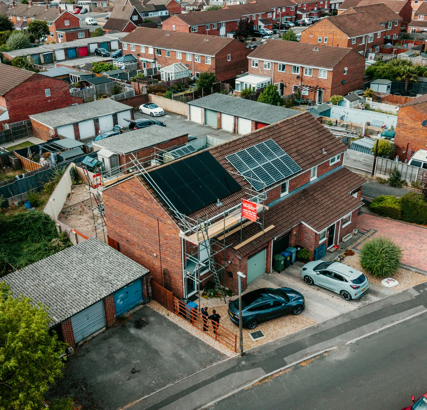 Solar House installers fitting panels from the scaffold